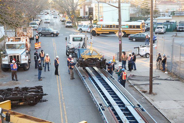 The train truck is placed on the trailer. 